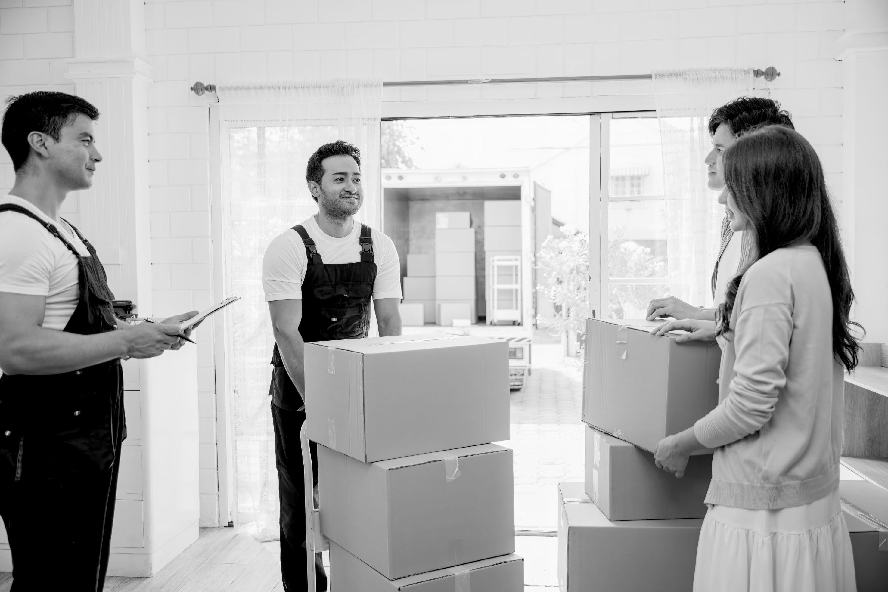 Moving team helping a couple with residential moving services indoors
