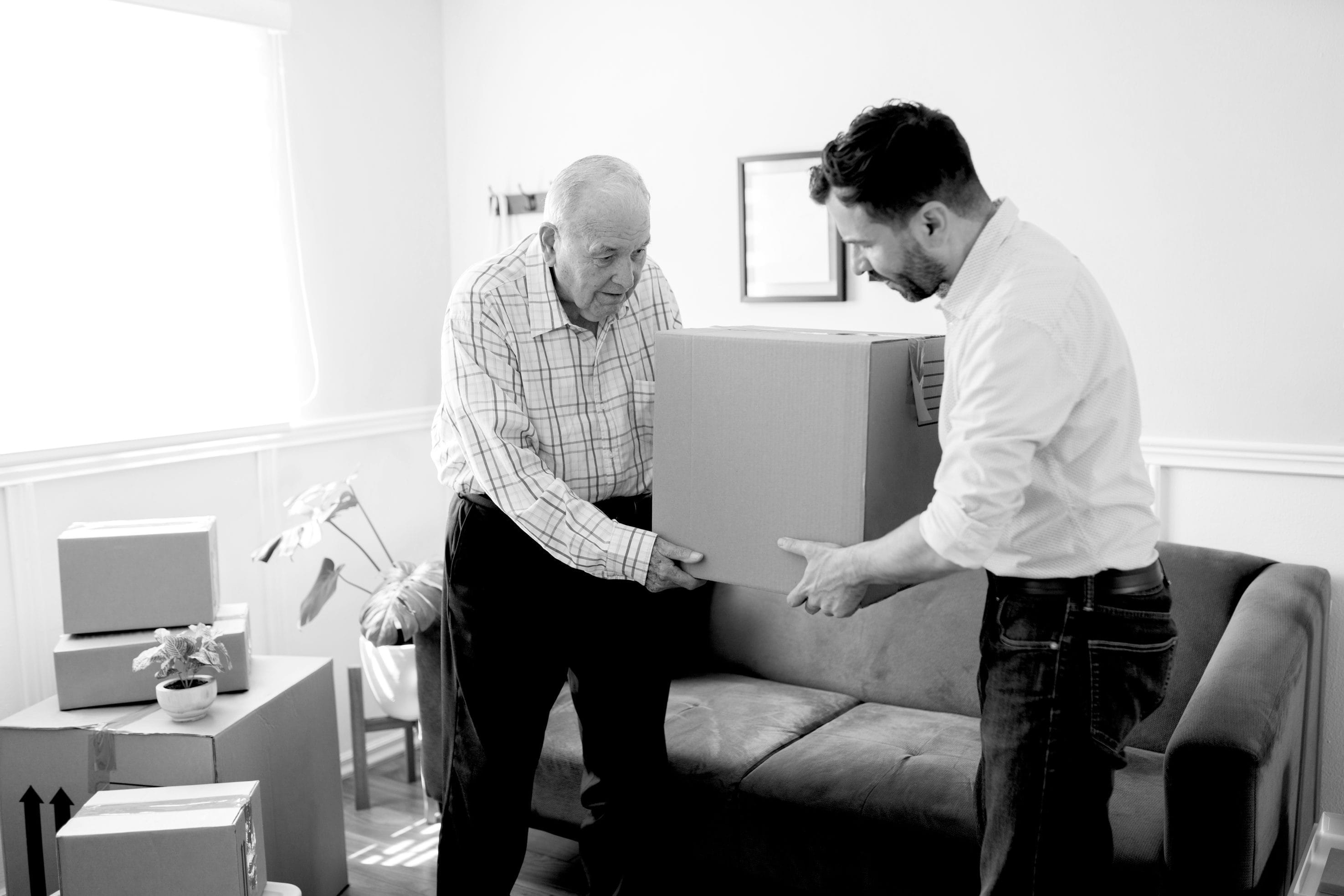 Senior Man Receiving Assistance with Moving Boxes
